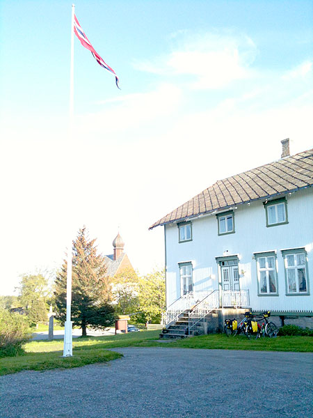 Dønnes gård med Dønnes kirke i bakgrunnen.