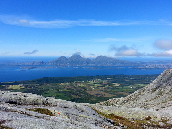 Utsikt fra aksla mellom Tvillingan og Skjærdingen. Ser hele Hærey og Dønna og den karakteristiske haifinneprofilen til Lovund litt lengre ute.