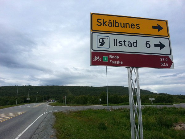 ... kan man svinge til høyre og følge den gamle veien inn til Bodø. Her er det så og si bilfritt. Tidligere så var det nødvendig å sykle noen km på veiskulderen ved Hopen - noe som var svært ubehagelig da det var mye trafikk, men nå er det bygget ny bro med gang og sykkelfelt over fjorden så nå er det gang og sykkelsti (eller lite trafikkert vei) hele veien fra skiltet på bildet og inn til Bodø by.