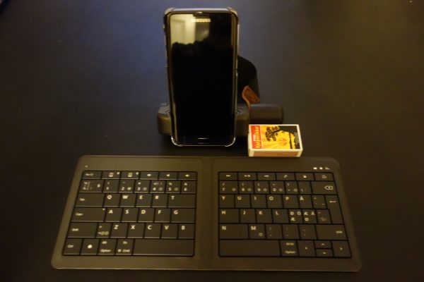 Min blogg-plattform på tur. En Samsung Galaxy S7 og et sammenleggbart Microsoft tastatur (Microsoft Foldable Keyboard). Fyrstikkesken er lagt der for å ha noe å vise størrelsen i forhold til - det er en standard fyrstikkeske.